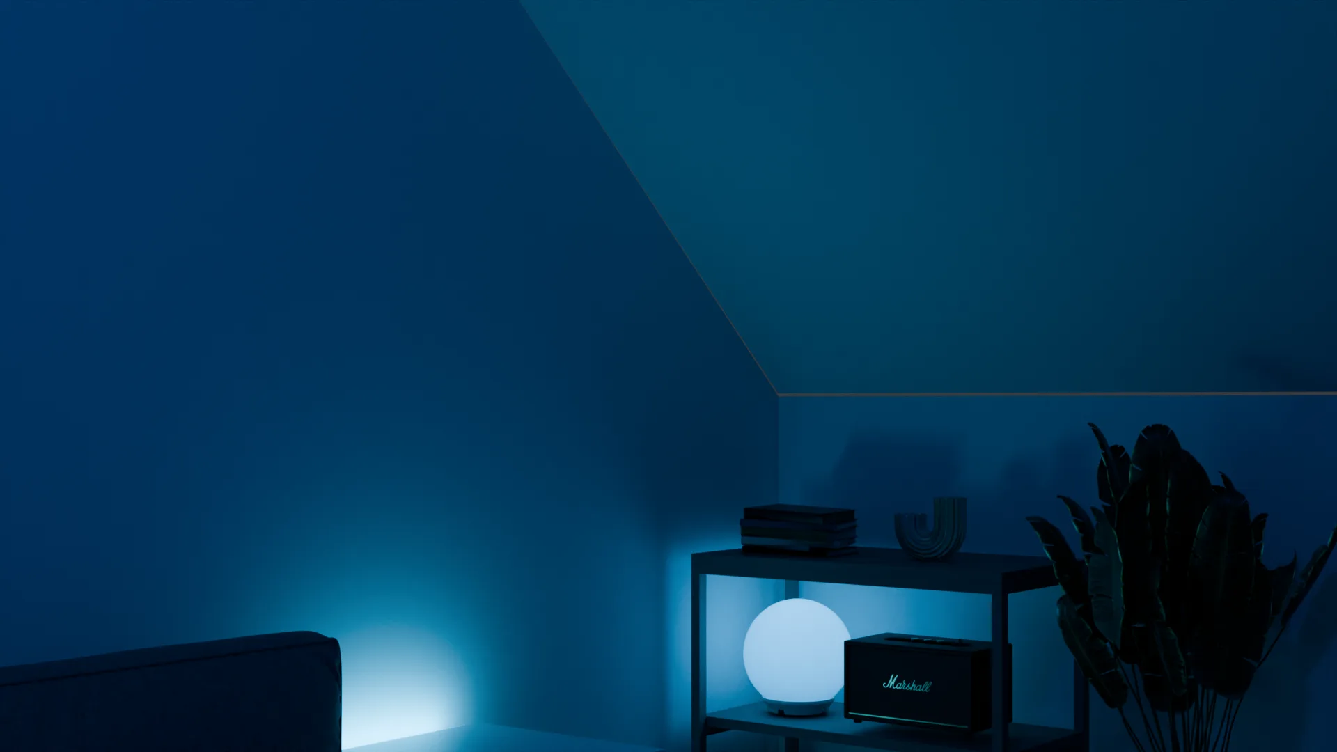 Le coin sous la pente : étagère avec lampe boule, enceinte et plante.